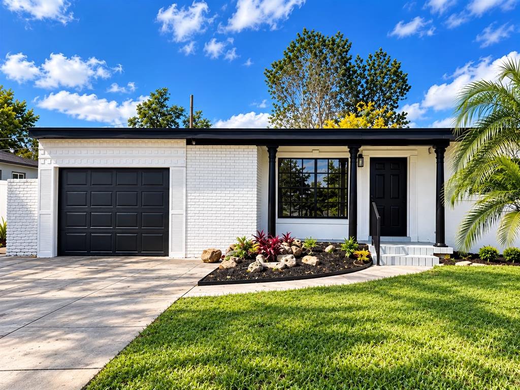 A single-story white brick house with a black garage door, front door, and trim — 1804 EDMUNDSHIRE ROAD, ORLANDO, FL