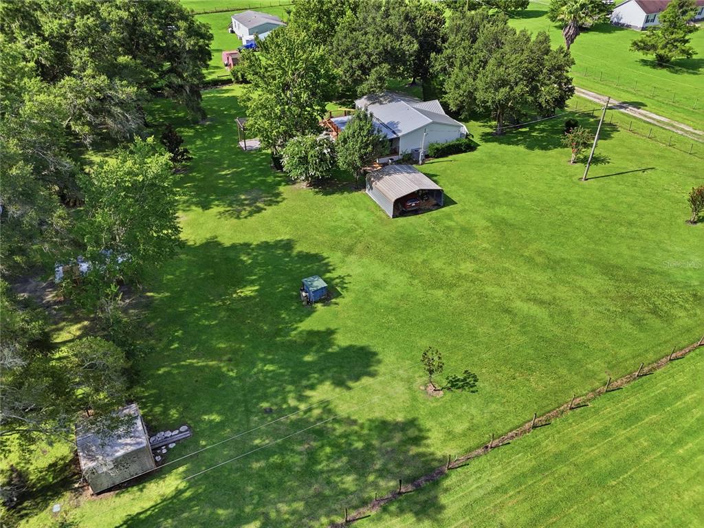 An aerial view shows a house with a metal carport on a large, grassy lot — 22930 NW 50TH LANE, NEWBERRY, FL