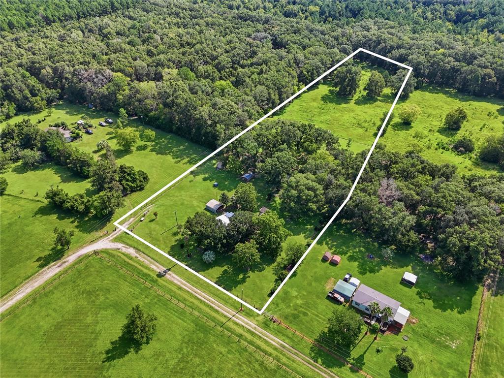An aerial view shows a rural property with a house, outbuildings, and fenced pasture land — 22930 NW 50TH LANE, NEWBERRY, FL
