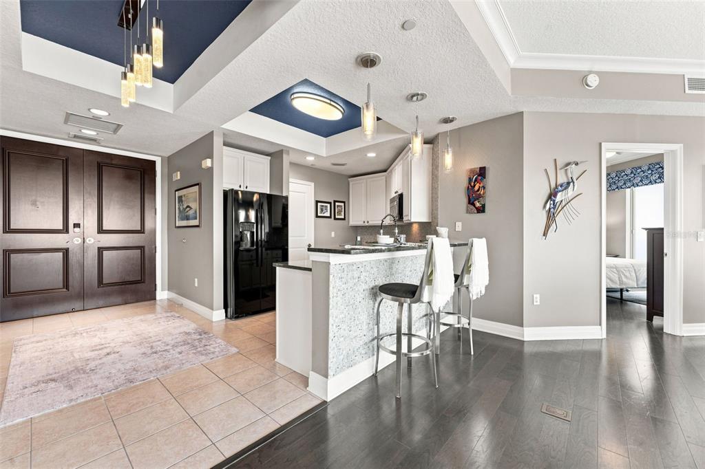 A kitchen with a breakfast bar, dark wood floors, and a blue-accented tray ceiling — 1209 E CUMBERLAND AVENUE UNIT 1404, TAMPA, FL
