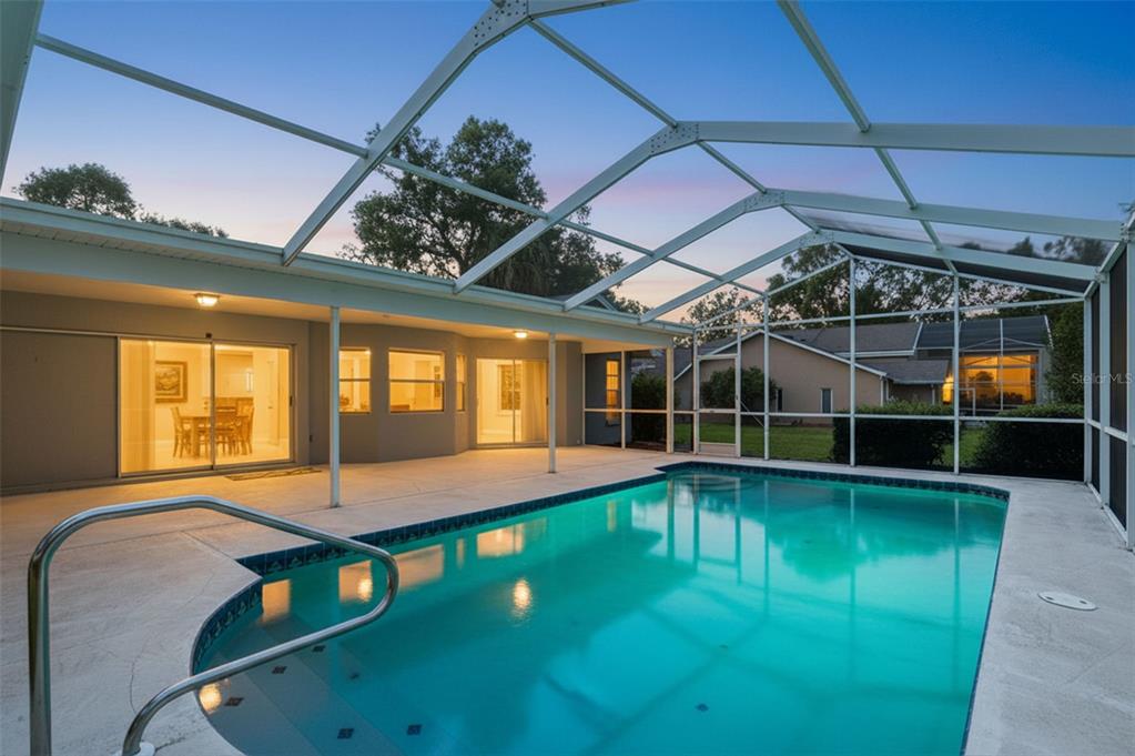A single-story house with a brick facade, gray siding, and two white garage doors — 18451 WINDING OAKS BOULEVARD, HUDSON, FL
