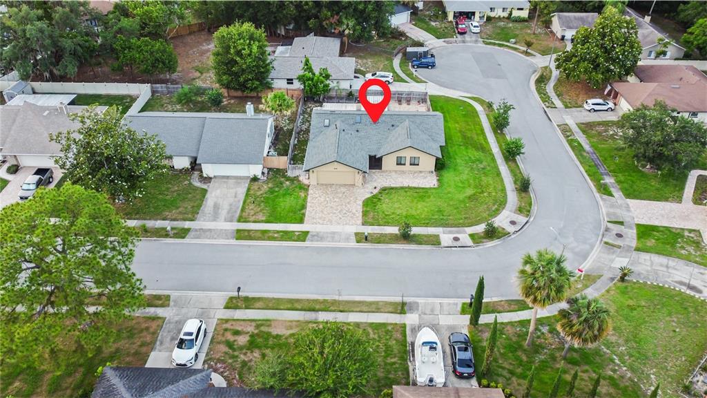 An aerial view shows a suburban house with a gray roof and a paved driveway — 1616 E SANDPIPER TRAIL, CASSELBERRY, FL