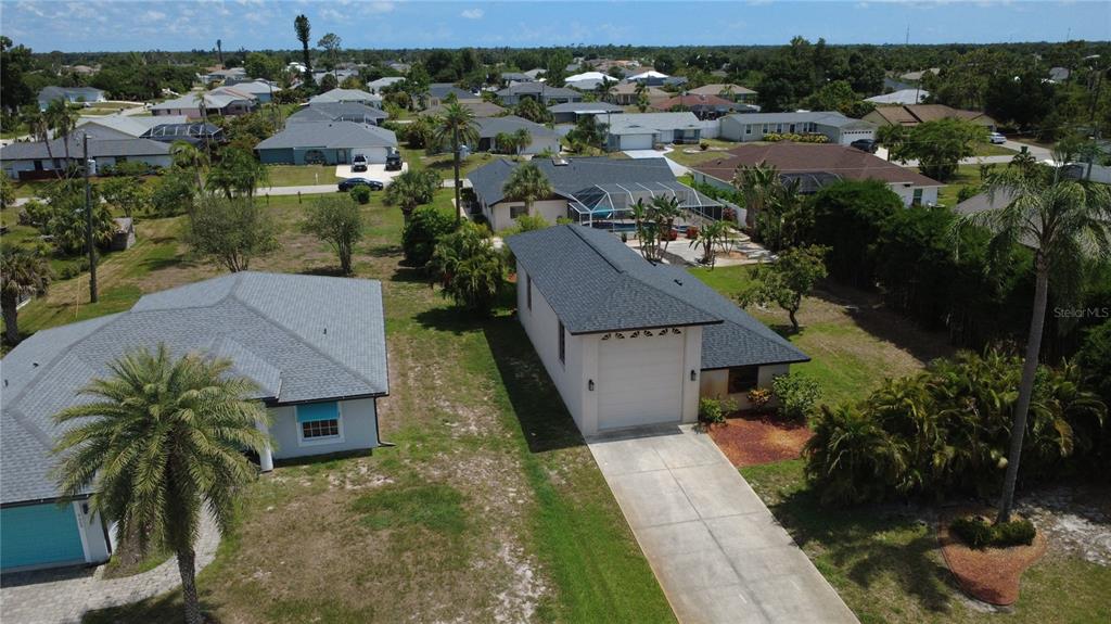 An aerial view shows two suburban houses with driveways and palm trees in a neighborhood — 9438 CRUGAR, ENGLEWOOD, FL