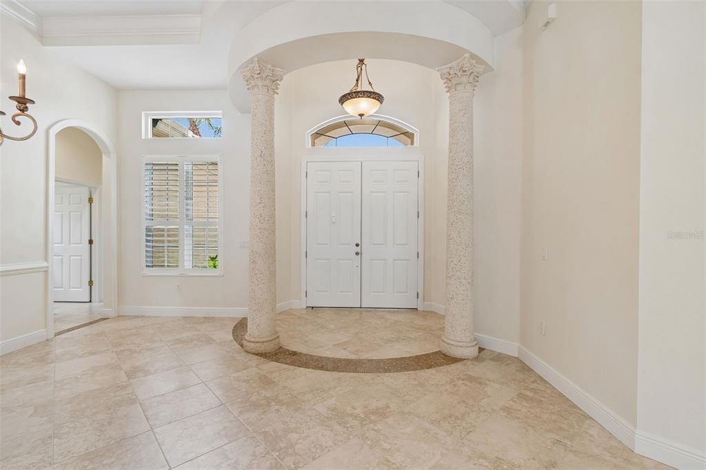 An entryway features two decorative columns, a tiled floor, and a double front door — 7222 LAKE FOREST GLEN, BRADENTON, FL