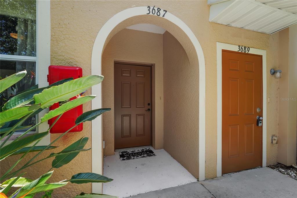 Two adjacent residential entry doors with house numbers 3687 and 3689 on a stucco exterior — 3687 PARKRIDGE CIRCLE UNIT 8-106, SARASOTA, FL