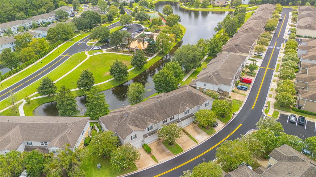 An aerial view shows townhomes, a winding road, a small pond, and landscaped green spaces — 435 WALNUT DRIVE, ST JOHNS, FL