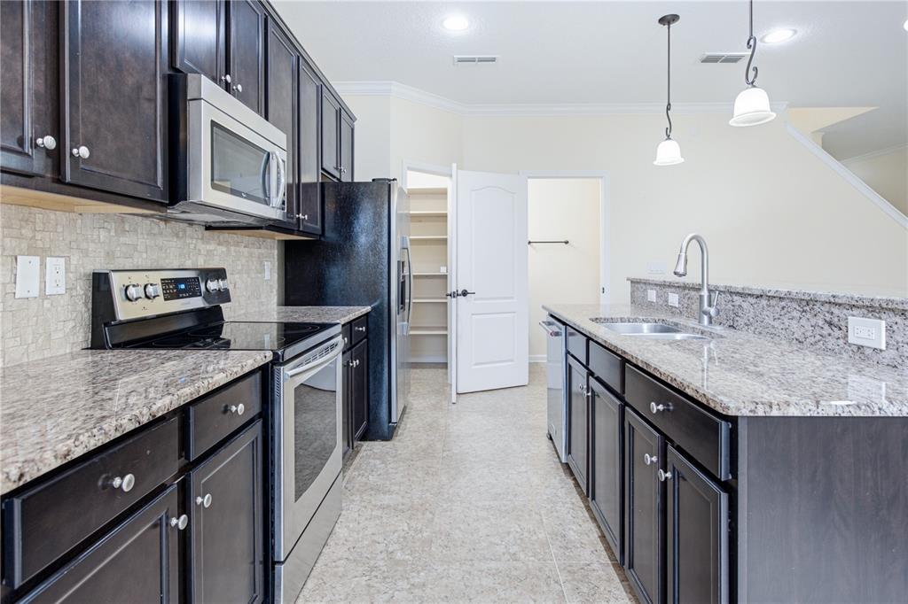 A kitchen features dark wood cabinets, granite countertops, stainless steel appliances, and a walk-in pantry — 435 WALNUT DRIVE, ST JOHNS, FL