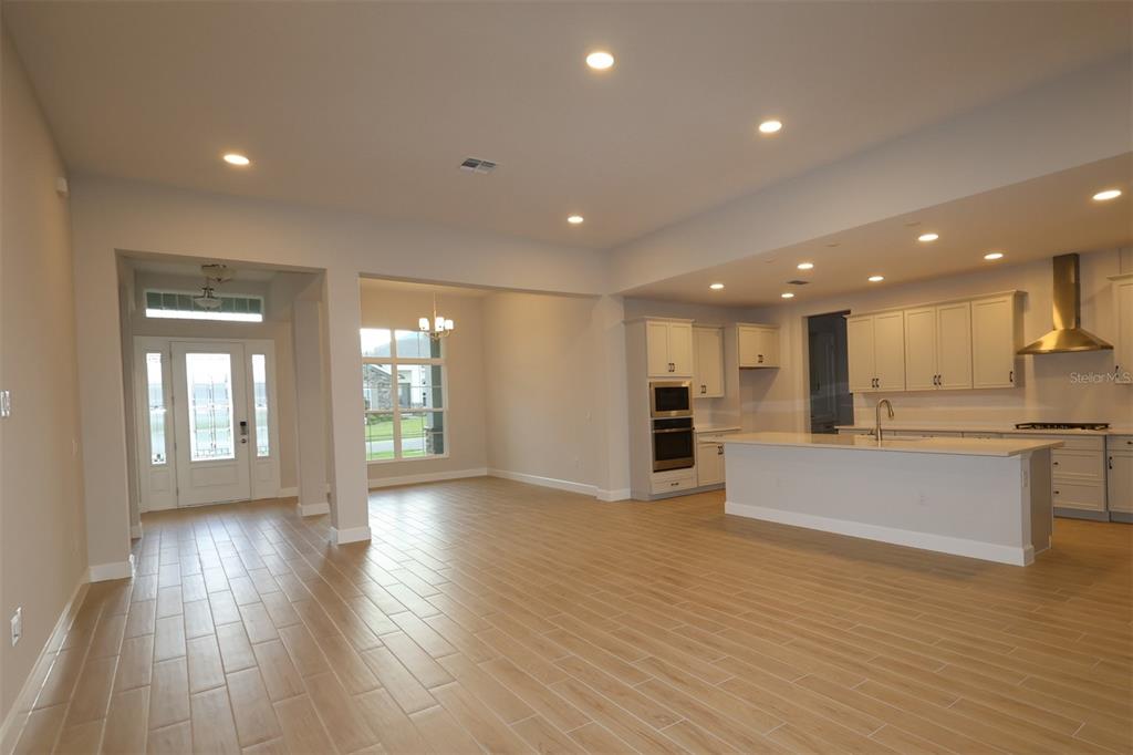 An unfinished kitchen features drywall, recessed lighting, and a central island under construction — 3193 WOLF LAKE AVENUE, APOPKA, FL