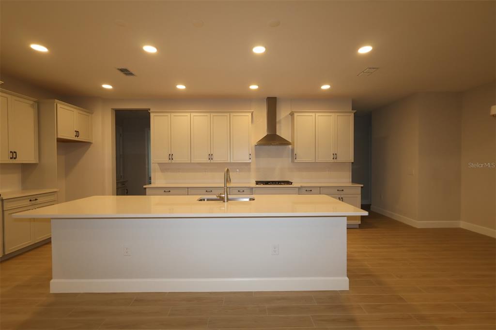 An unfinished room features drywall walls, a low partition wall, and recessed ceiling lighting — 3193 WOLF LAKE AVENUE, APOPKA, FL