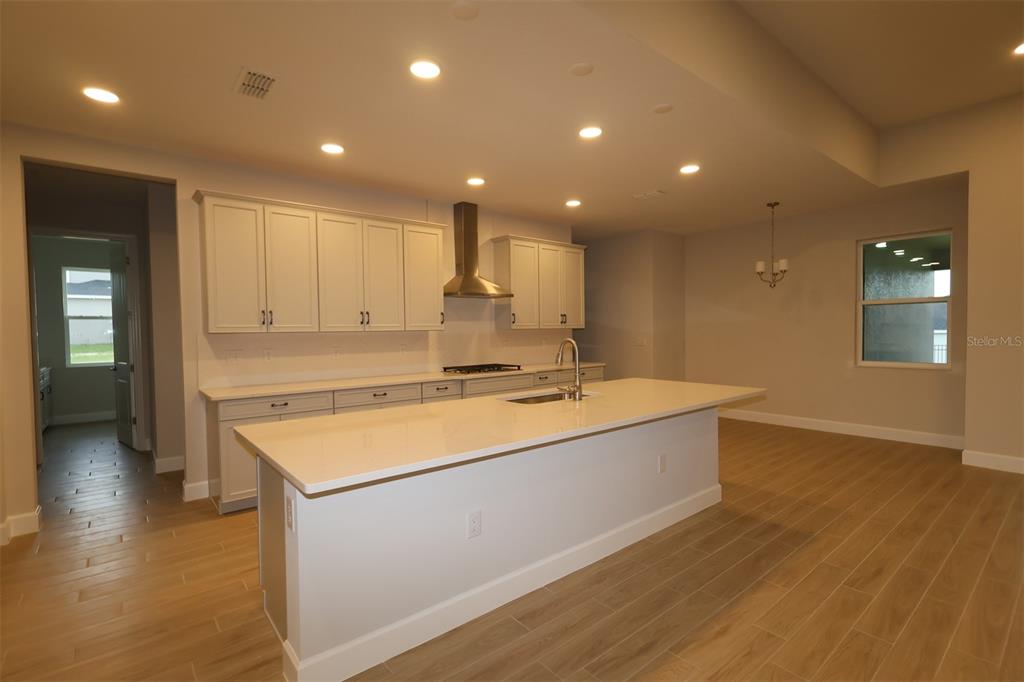 An unfinished room features drywall, a textured ceiling, and three windows overlooking a neighborhood — 3193 WOLF LAKE AVENUE, APOPKA, FL