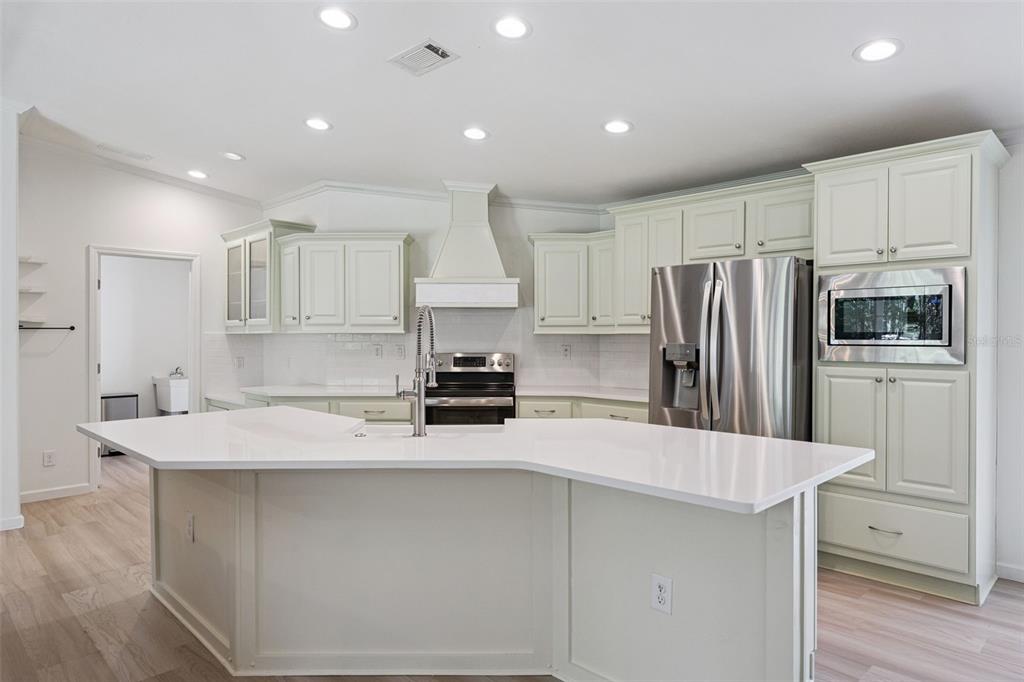 A living room features light wood flooring, a stone fireplace, and a sliding glass door — 1161 LAKE HARNEY WOODS BOULEVARD, MIMS, FL