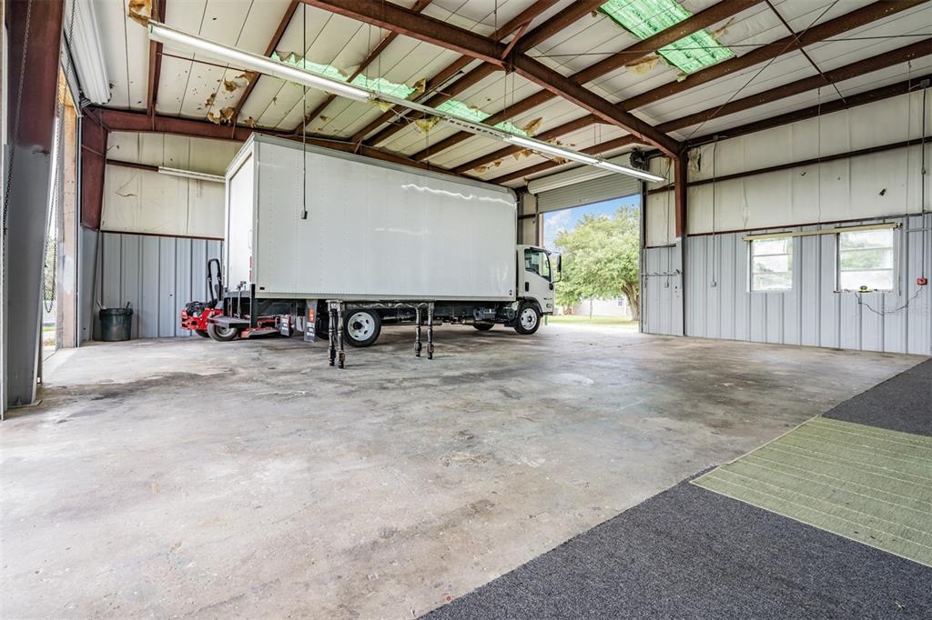 A large, industrial warehouse space with a concrete floor and a parked box truck inside — 33144 MCCABE ROAD, SAN ANTONIO, FL
