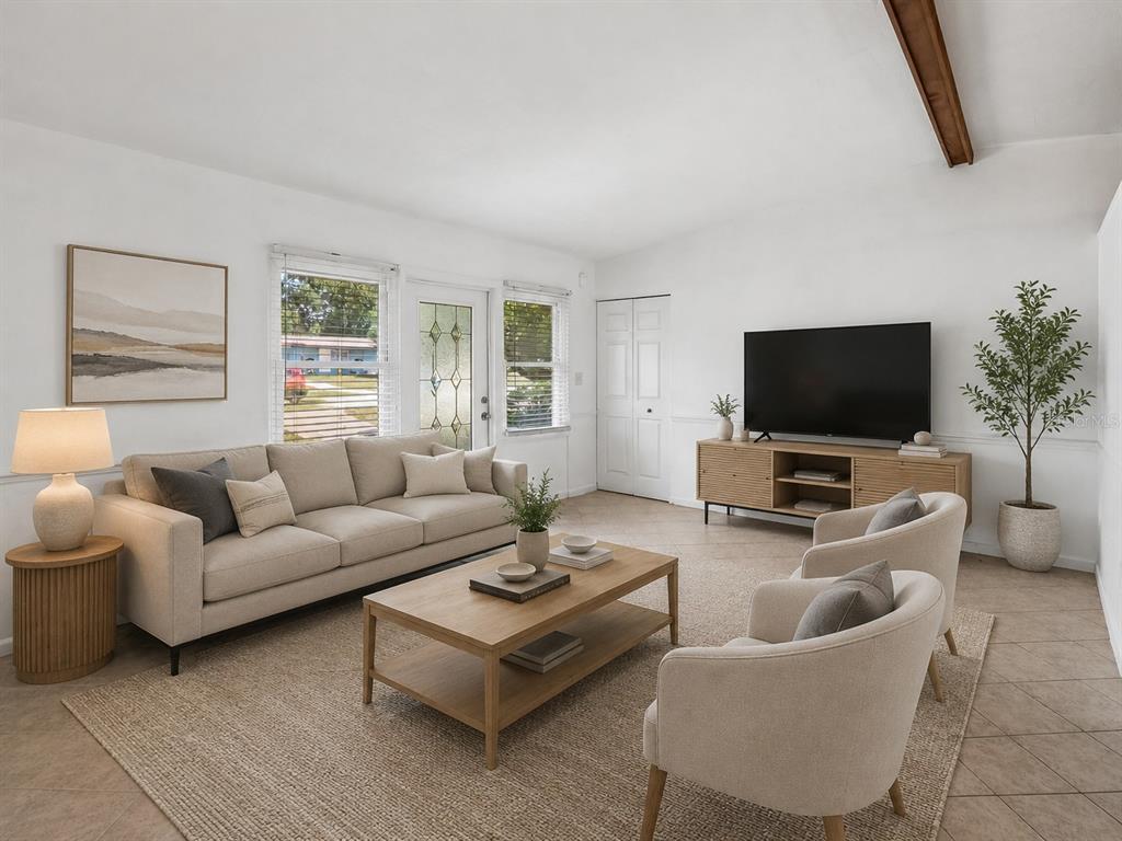A living room features a beige sofa, two armchairs, a coffee table, and a television — 572 E NORMANDY BOULEVARD, DELTONA, FL