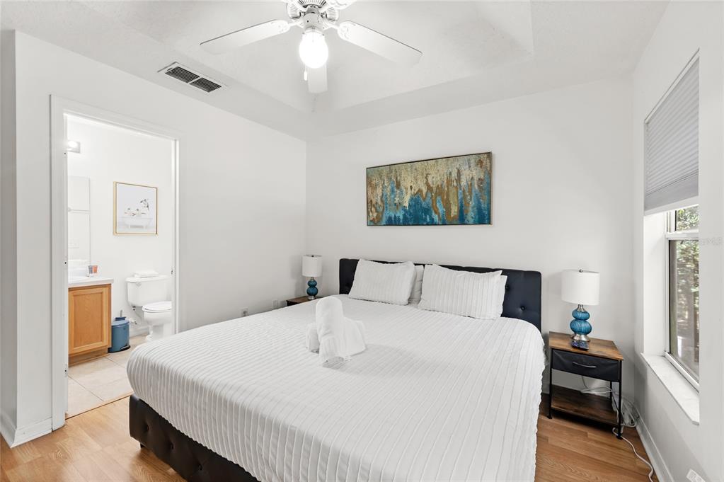 A bedroom features a king bed, a ceiling fan, and an attached bathroom — 2685 ANDROS LANE, KISSIMMEE, FL