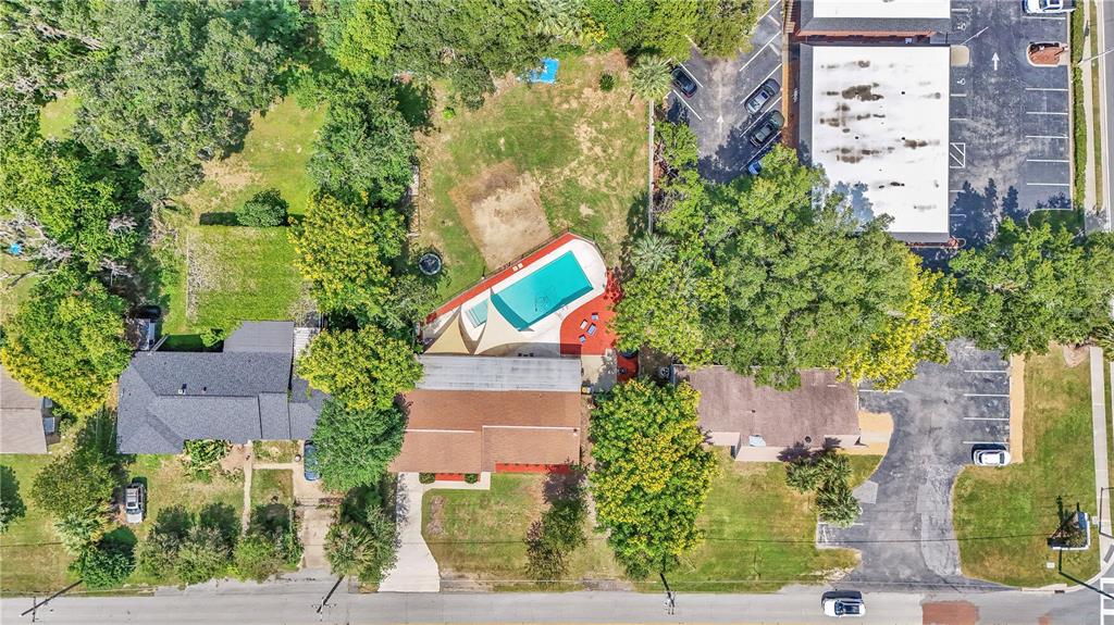 An aerial view shows a house with a backyard swimming pool and surrounding parking lots — 2433 NE 2ND STREET, OCALA, FL