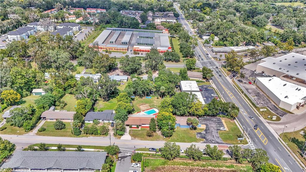 An aerial view shows a residential property with a swimming pool near a busy road — 2433 NE 2ND STREET, OCALA, FL