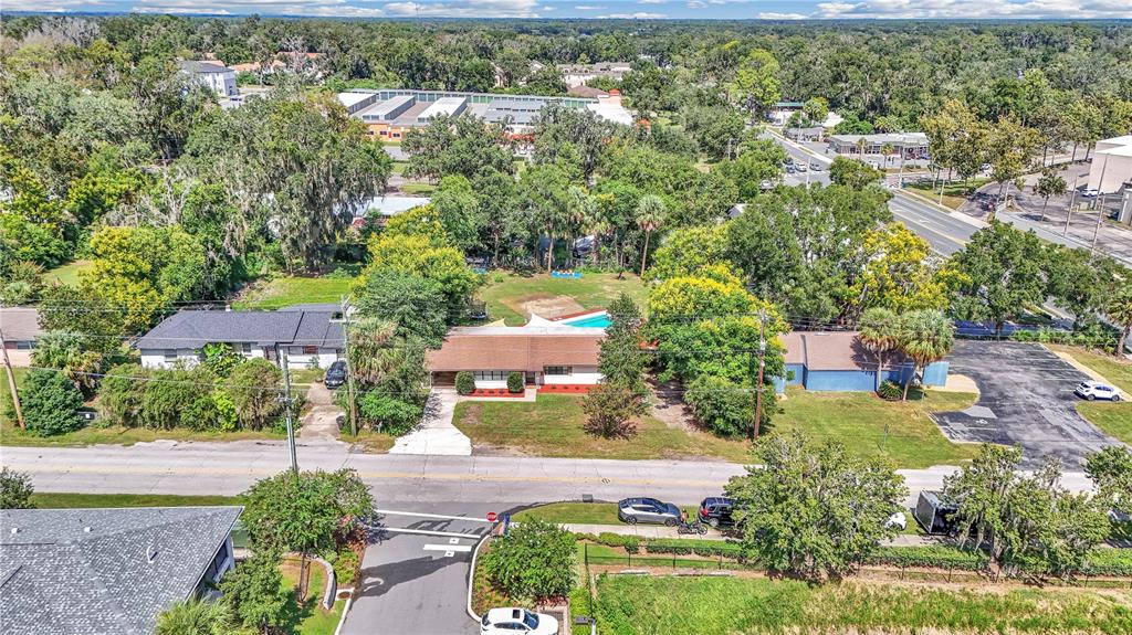 An aerial view shows a single-story house with a swimming pool and a large parking lot — 2433 NE 2ND STREET, OCALA, FL