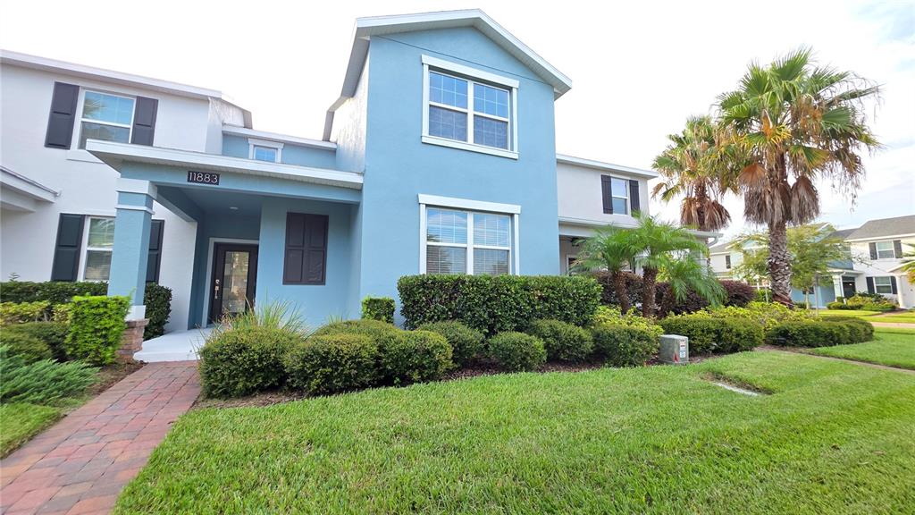 A dark brown front door with a glass insert is set in a blue wall — 11883 PULITZER PLACE, ORLANDO, FL