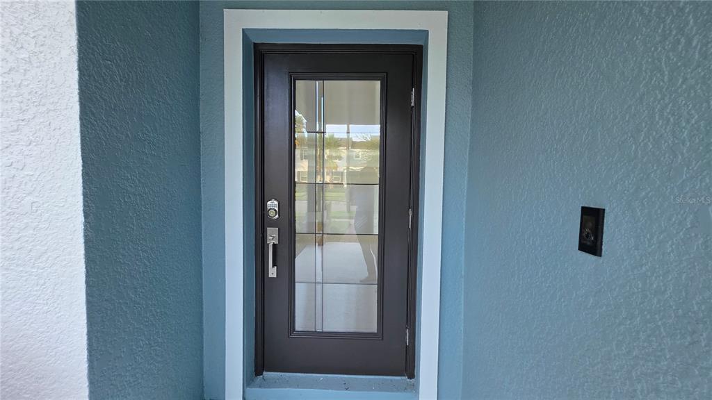 The exterior of a blue house features a brick walkway leading to a front entrance — 11883 PULITZER PLACE, ORLANDO, FL