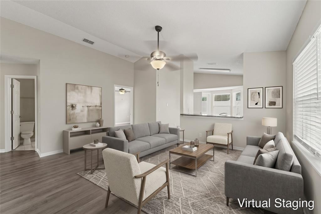 A living room with light gray walls, wood-look flooring, a ceiling fan, and a pass-through — 10236 FLAGSHIP AVENUE, PORT RICHEY, FL
