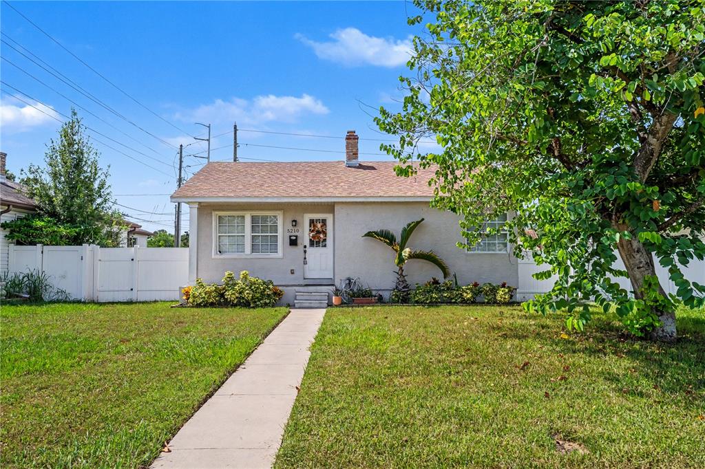 A single-story house with a light-colored exterior, a shingled roof, and a front walkway — 5210 4TH AVENUE N, ST PETERSBURG, FL