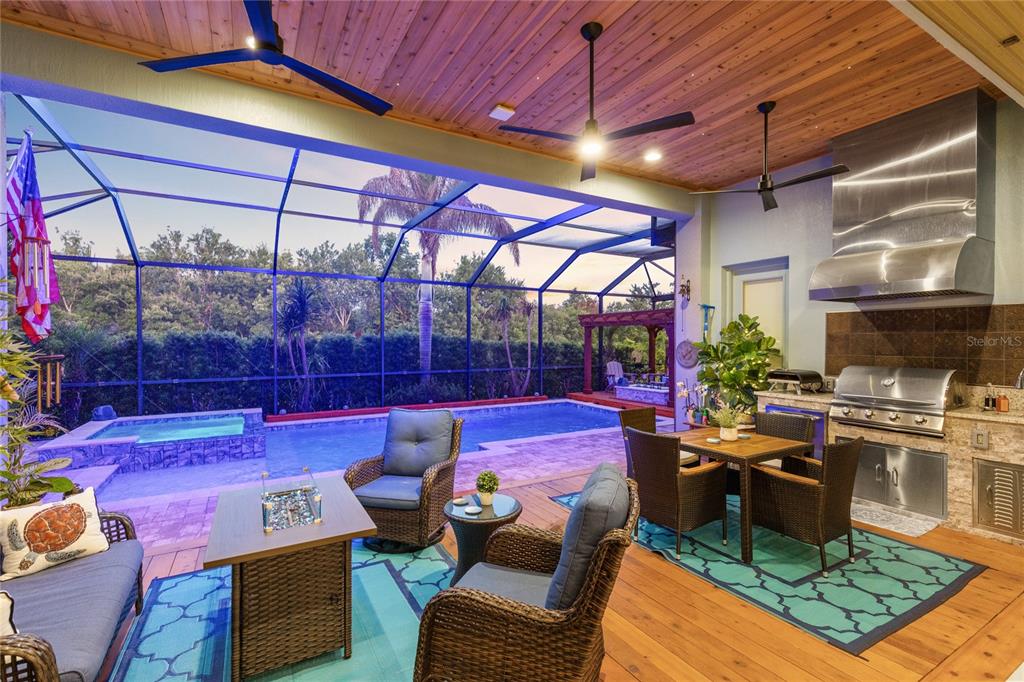 A kitchen features dark wood cabinets, a large central island with seating, and light countertops — 13391 ALDERLEY DRIVE, ORLANDO, FL