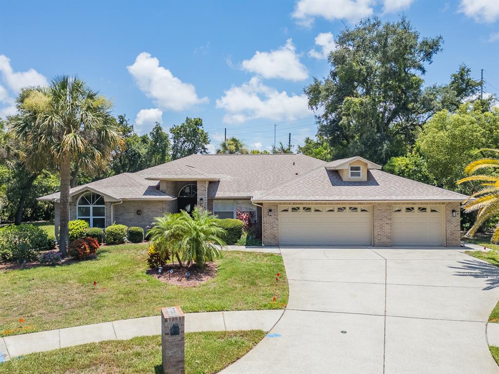 A single-story brick house with a three-car garage and a large front lawn — 2899 TURTLE TERRACE, PALM HARBOR, FL