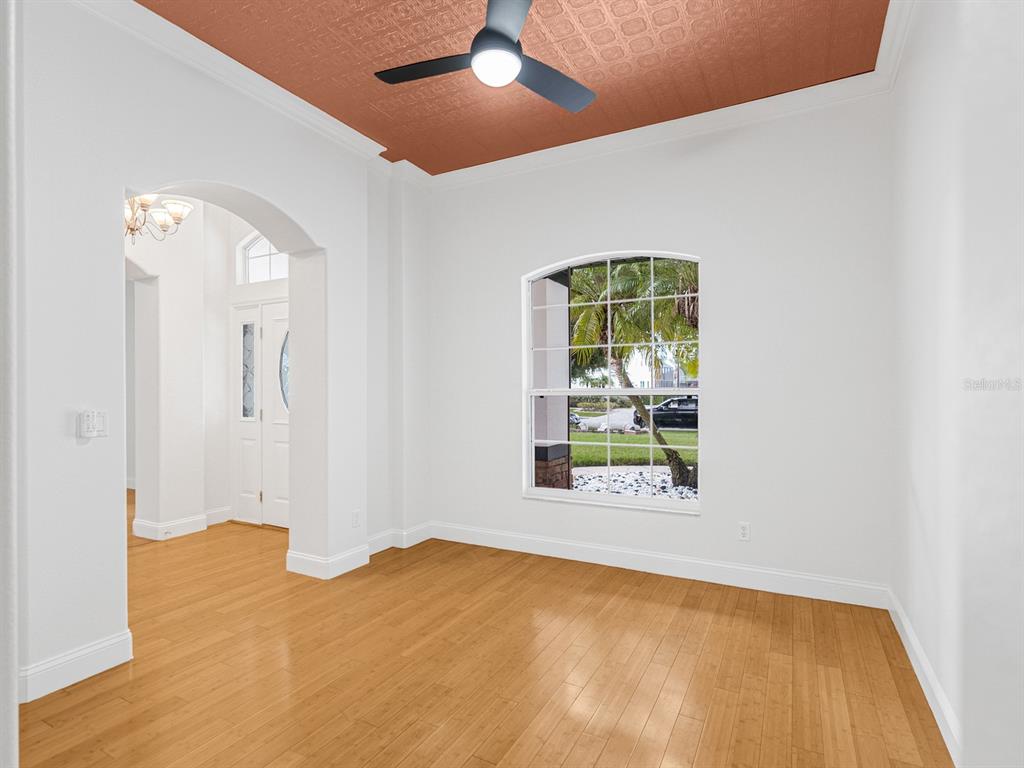 A room with light wood flooring, white walls, and a copper-colored patterned ceiling — 1670 TAYLOR RIDGE LOOP, KISSIMMEE, FL