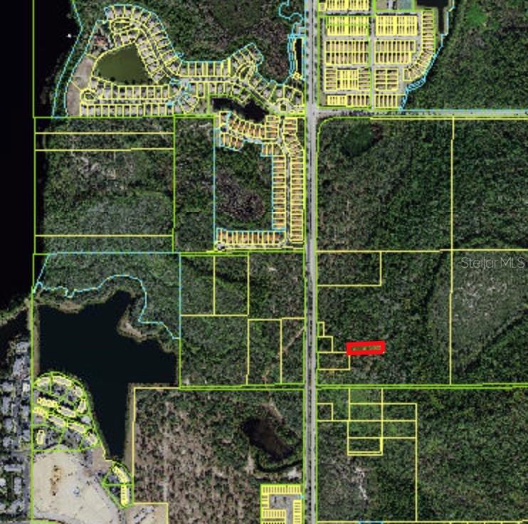 This is an aerial map showing a highlighted parcel of land surrounded by wooded areas — WESTSIDE BOULEVARD, KISSIMMEE, FL
