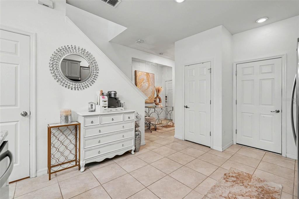 A tiled entryway features a white dresser, a decorative mirror, and several white doors — 5374 SYLVESTER LOOP, TAMPA, FL