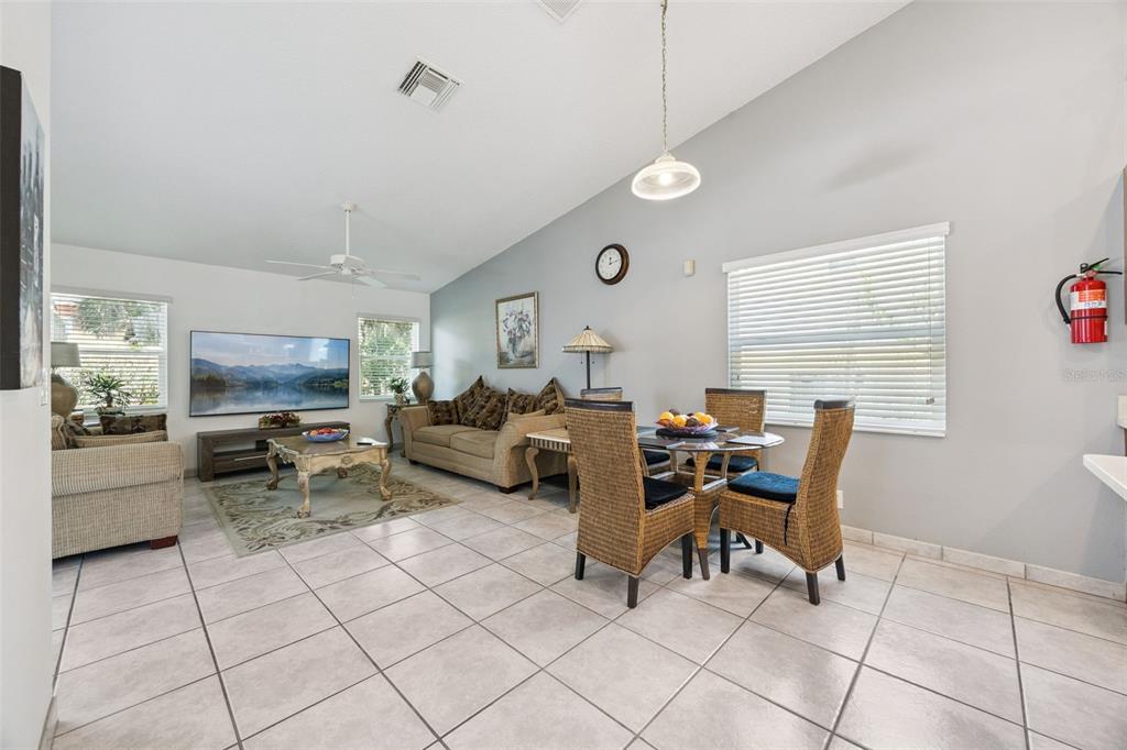 A living room with tile floors, a ceiling fan, and an open kitchen in back — 2948 PEMBRIDGE STREET, KISSIMMEE, FL
