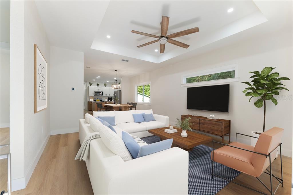 A single-story white house with a front porch and concrete driveway sits under large trees — 925 NE 17TH DRIVE, GAINESVILLE, FL