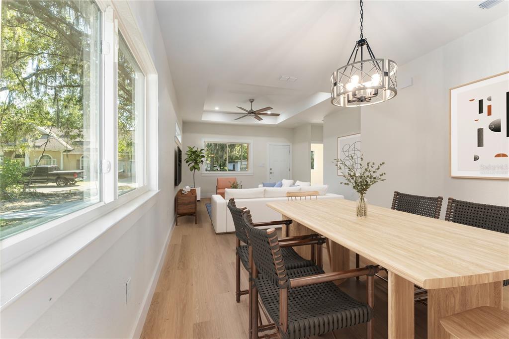A modern house exterior features white siding, a covered porch, and a wooden support post — 925 NE 17TH DRIVE, GAINESVILLE, FL