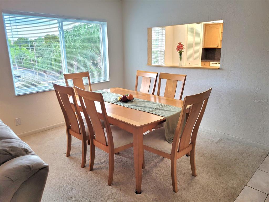 A bedroom features a wooden bed frame, a matching dresser with a mirror, and carpeted flooring — 9861 Sunrise Lakes  Blvd SUNRISE LAKES BOULEVARD UNIT 310, SUNRISE, FL