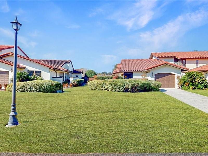 A street-level view shows two suburban houses with tile roofs and manicured green lawns — 118 COVENTRY LANE, HAINES CITY, FL