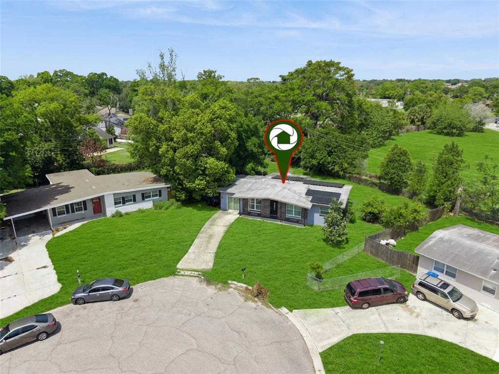 An aerial view shows a single-story house with solar panels on a suburban cul-de-sac — 6204 OAKCREST CIRCLE, ORLANDO, FL
