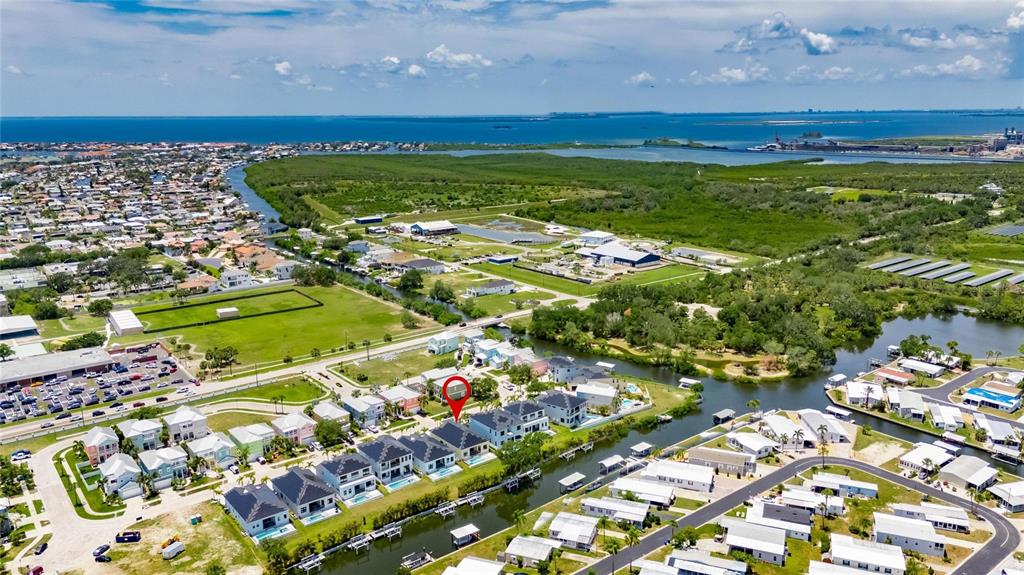 An aerial view shows a residential neighborhood with a canal and a marked house — 6532 SIMONE SHORES CIRCLE, APOLLO BEACH, FL