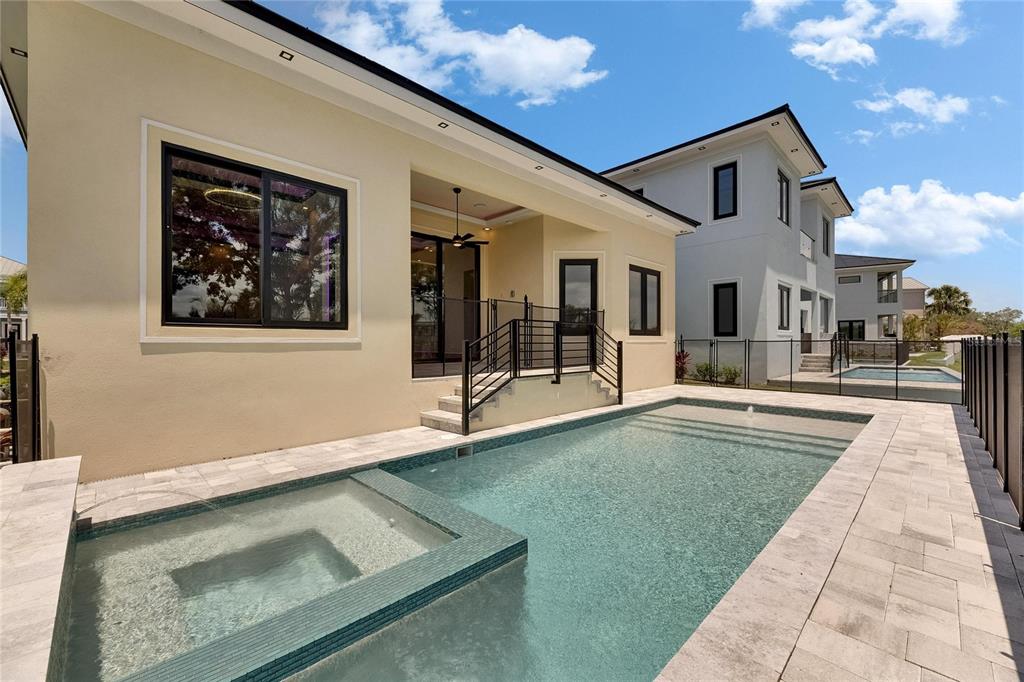 A backyard features a swimming pool with an attached spa and a beige house exterior — 6532 SIMONE SHORES CIRCLE, APOLLO BEACH, FL