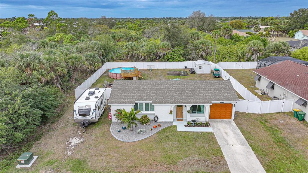 A backyard features a concrete patio with outdoor furniture, a white fence, and a shed — 18970 MCGRATH CIRCLE, PORT CHARLOTTE, FL
