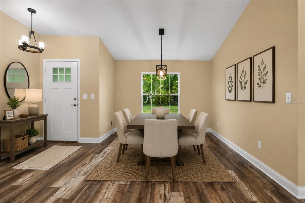 A dining room features a wooden table, six upholstered chairs, a pendant light, and wall art — 6929 WILBAR LANE, HAINES CITY, FL