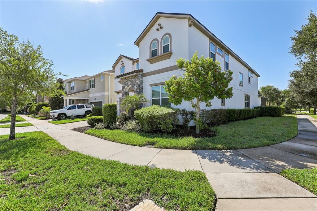 A two-story suburban house with a stone-accented entrance and a white exterior facade — 9001 SUNSHINE RIDGE LOOP, KISSIMMEE, FL