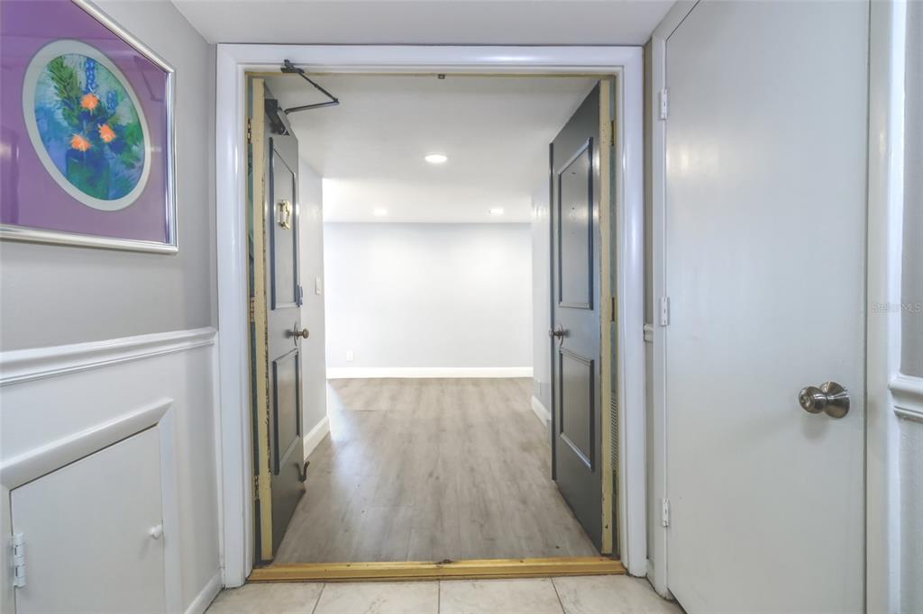 A doorway with open dark doors leads from a tiled hallway into a room — 220 BELLEVIEW BOULEVARD UNIT 812, BELLEAIR, FL