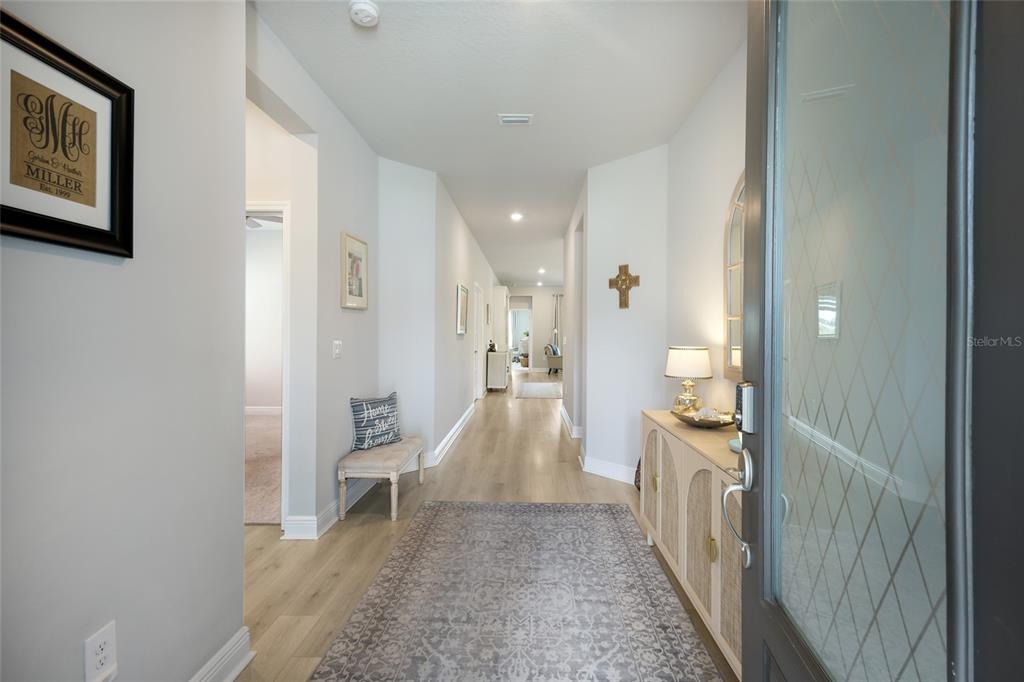 A covered front porch features light blue walls, white columns, and a dark front door — 8611 MERCATOR COURT, PARRISH, FL