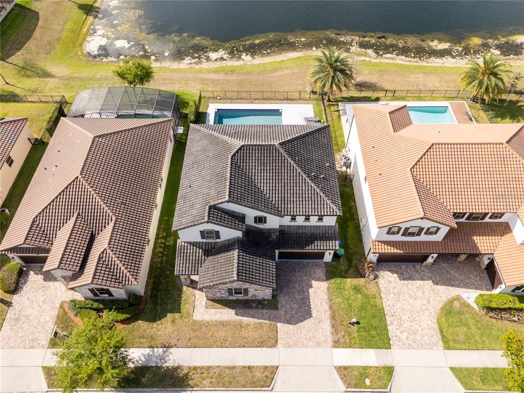 An aerial view shows three suburban houses with tiled roofs, private pools, and paved driveways — 17526 BLACK RAIL STREET, WINDERMERE, FL