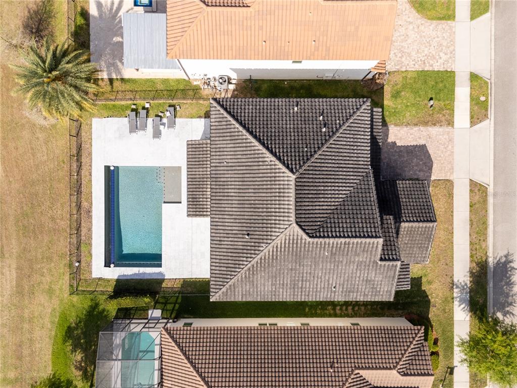 An aerial view shows a house with a dark tiled roof, pool, and patio area — 17526 BLACK RAIL STREET, WINDERMERE, FL
