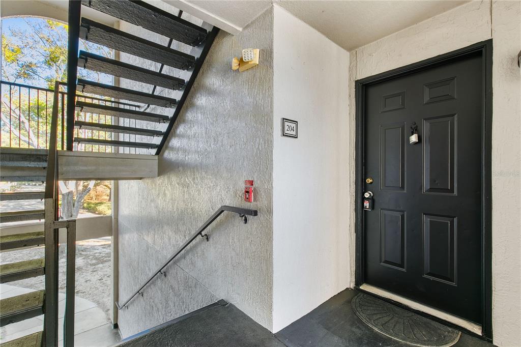 A kitchen features white cabinets, light countertops, and black appliances against light gray walls — 7605 PISSARRO DRIVE UNIT 13204, ORLANDO, FL