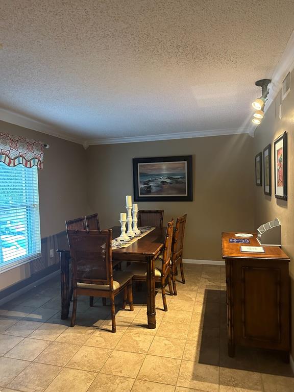 A dining room features a wooden table with chairs, tile flooring, and wall-mounted artwork — 600 CRANES WAY UNIT 204, ALTAMONTE SPRINGS, FL