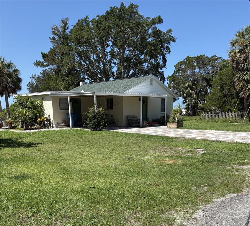 A single-story house with a green roof, covered porch, and a paved driveway — 3044 SUNSET VISTA DRIVE, SPRING HILL, FL