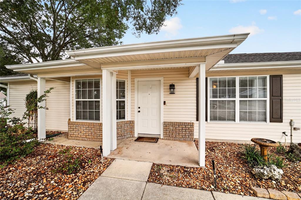 A single-story house with light siding, a two-car garage, and a concrete driveway — 8661 SW 65TH TERRACE, OCALA, FL