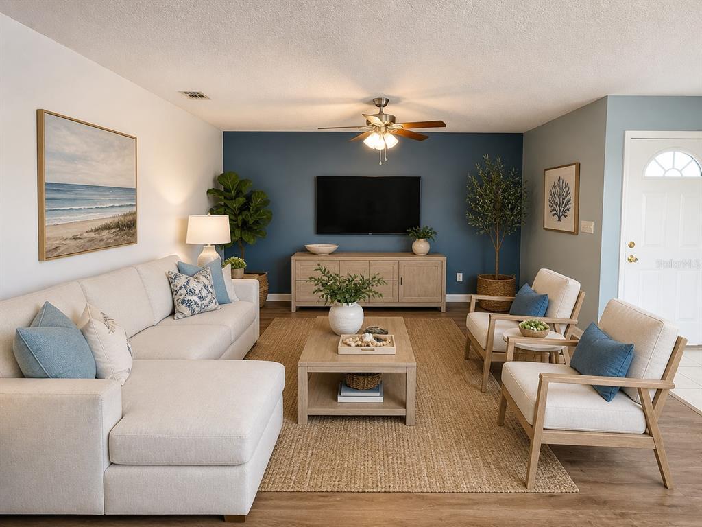 A living room features a blue accent wall, a sectional sofa, and two wooden armchairs — 1013 APOLLO BEACH BOULEVARD UNIT 202, APOLLO BEACH, FL